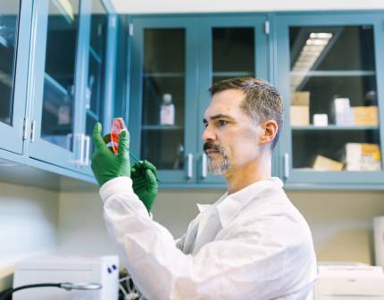 Carlos Rios looking at a sample in the laboratory