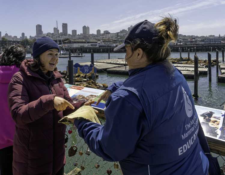a volunteer at PIER 39 interacts with a visitor