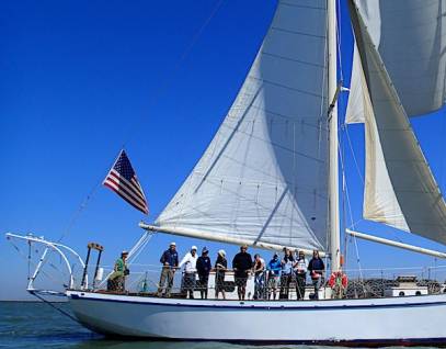 sailboat with a group of people looking over the side rail