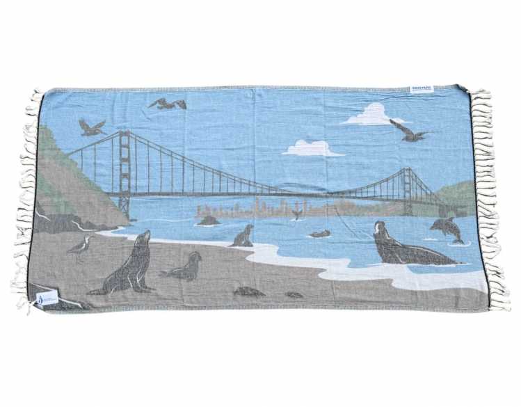 peach-colored lightweight beach towel with gray harbor seal and yellow sun design