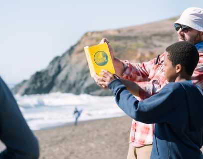 a teacher and student work together making observations at the beach