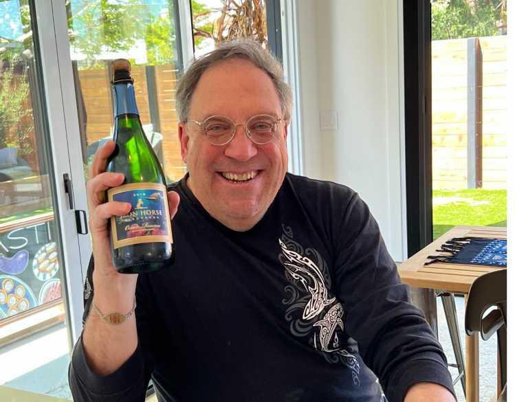 peter mandell holding a bottle of Iron Horse wine